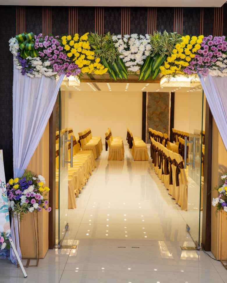 A floral-draped entrance archway leading into a hall set for a wedding ceremony