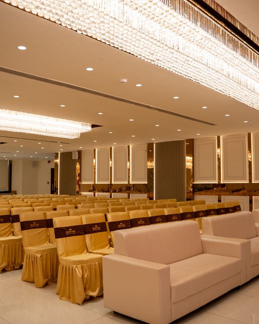 The main hall set with seating beneath long crystal chandeliers